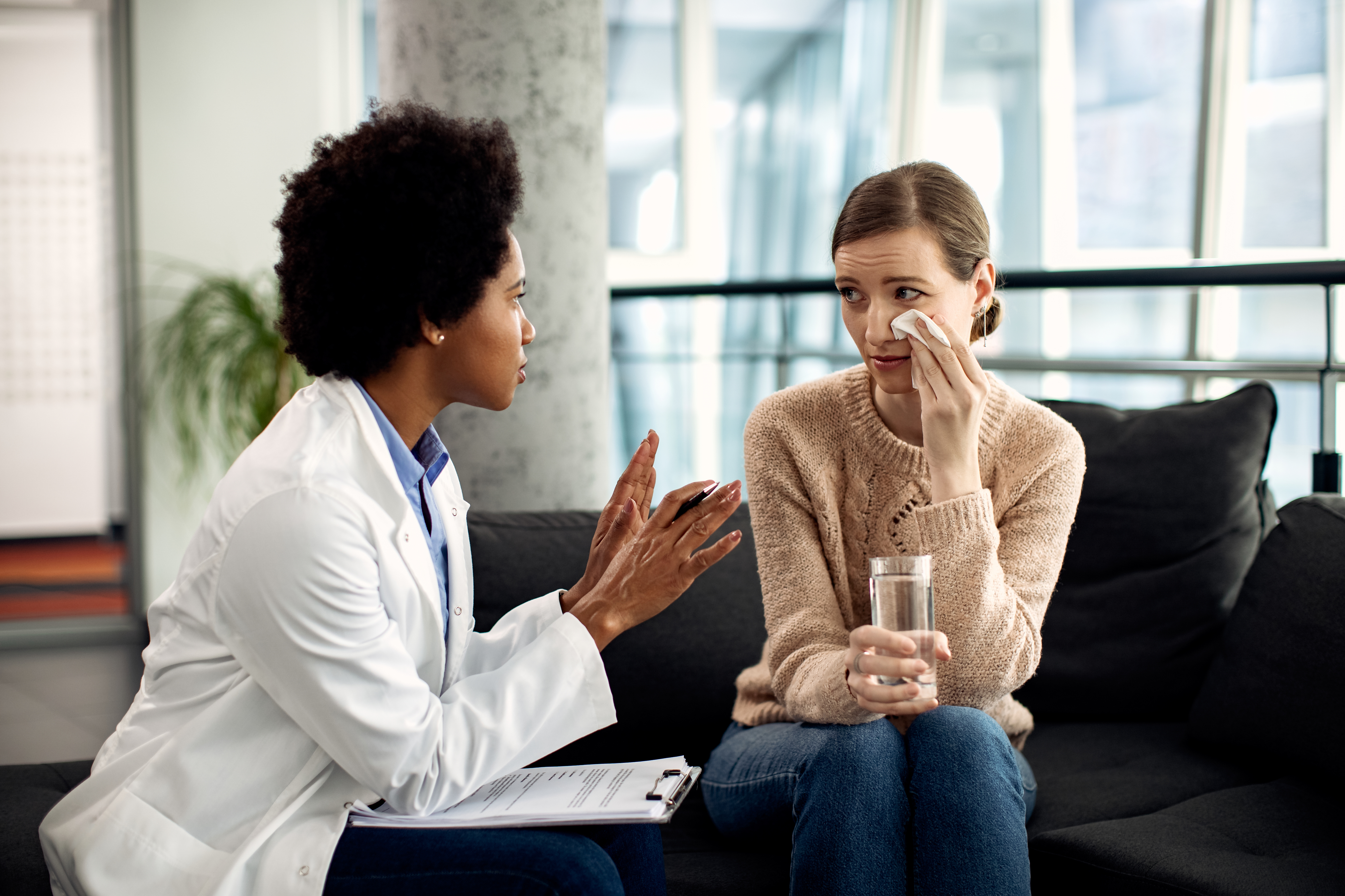 african american counselor talking to a crying woman during psyc